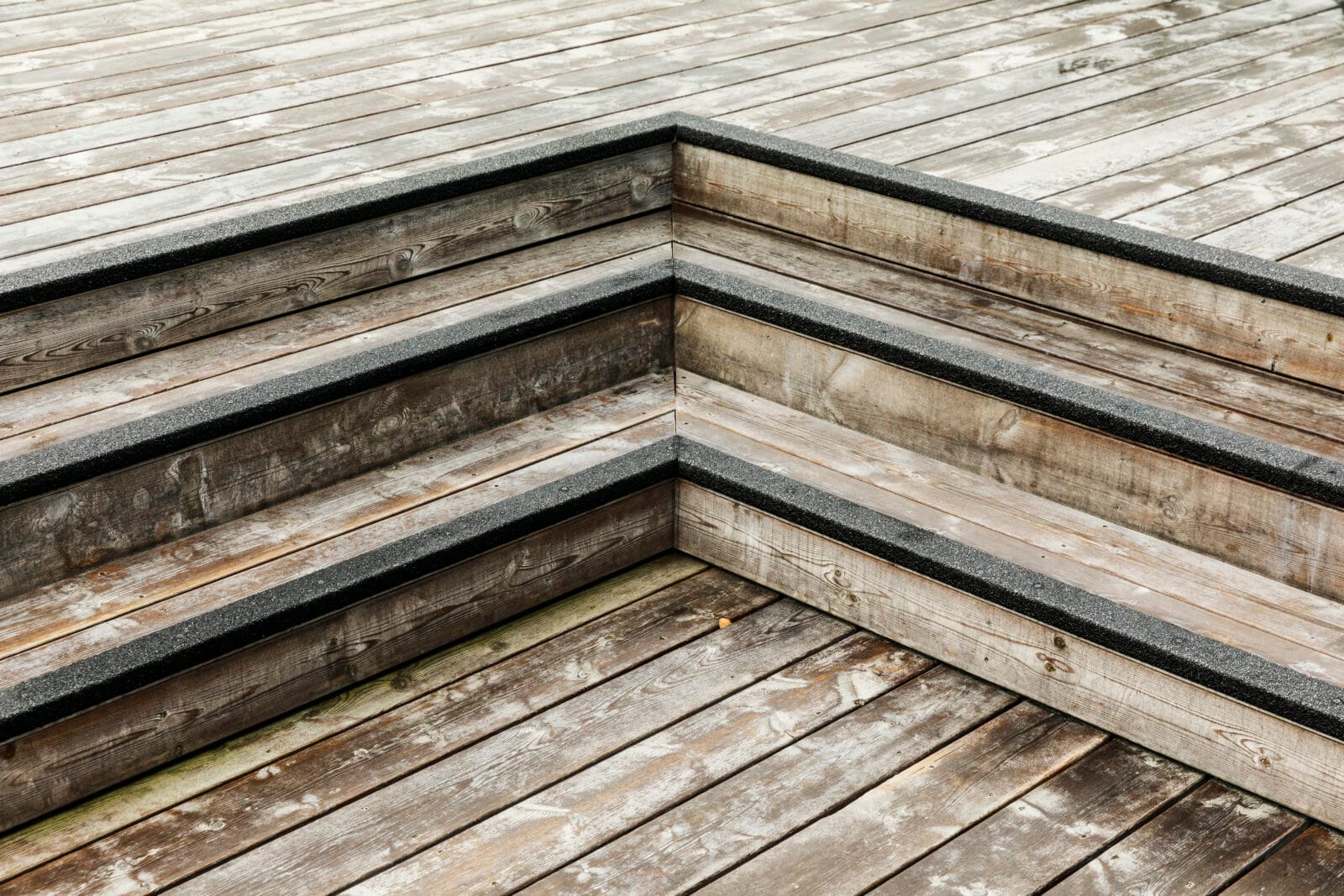 Svart trappnoslist i glasfiber på trappa i trä